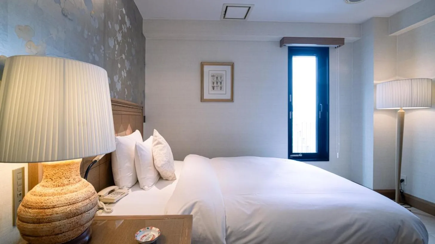 une chambre avec un lit, une lampe et une table à ホテルピュリッツァー自由が丘 à Tokyo