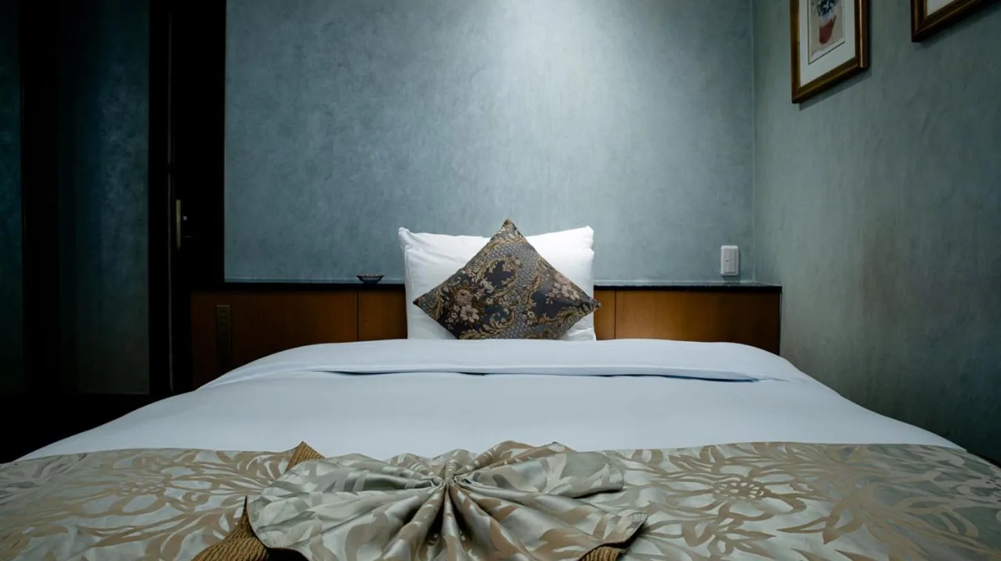 une chambre avec un grand lit blanc et un oreiller à ホテルピュリッツァー自由が丘 à Tokyo