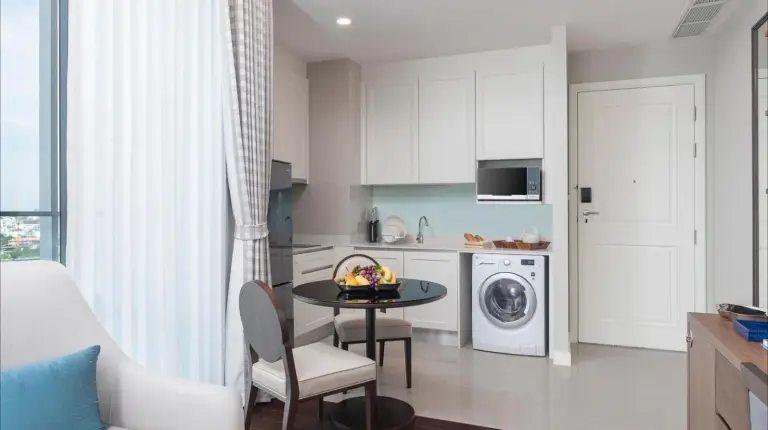 a kitchen and living room with a table and a couch at 137 Pillars Residences Bangkok in Bangkok