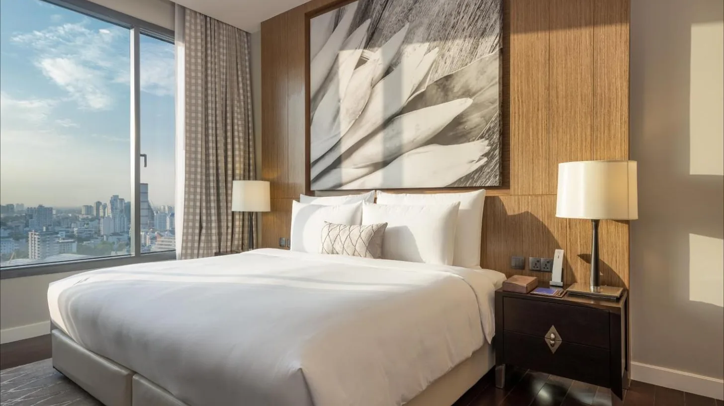 a bedroom with a large bed and a large window at 137 Pillars Residences Bangkok in Bangkok