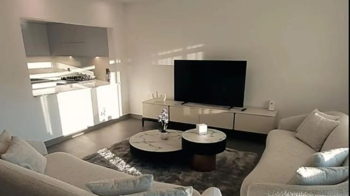 a living room with two couches and a flat screen tv at 2 Bedroom beach front apartment in Dubai