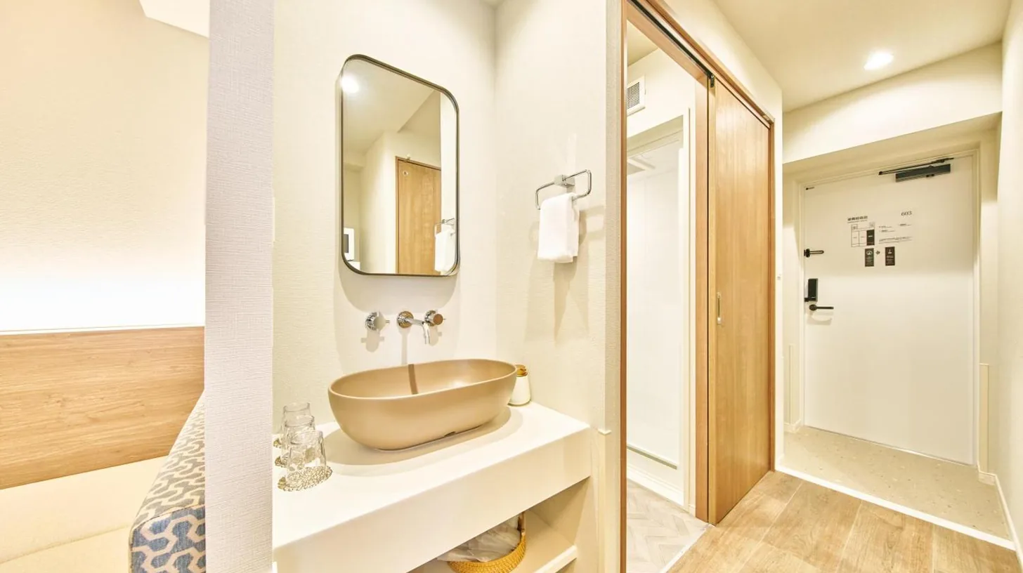 a small bedroom with a bed and a bench at 2026年7月New Open! Grand STAY Hakata Nishinakasu in Fukuoka