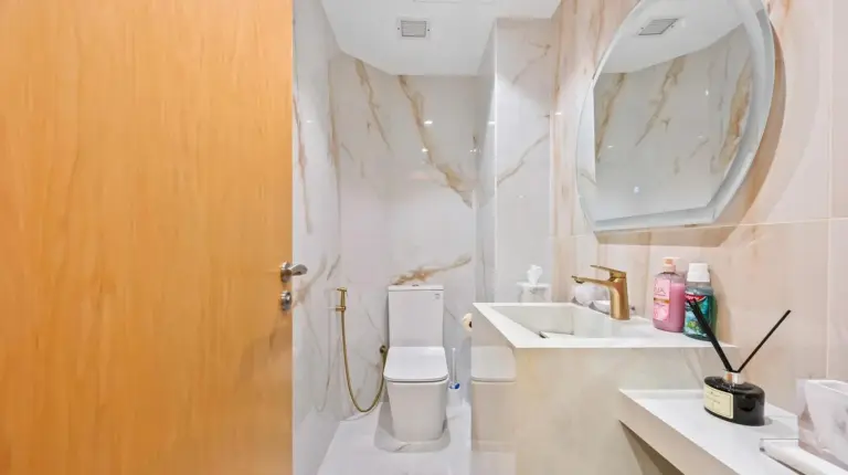 a bathroom with a toilet and a sink and a mirror at 2BDR Luxury Apartment in Palm in Dubai