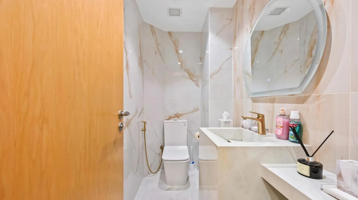 a bathroom with a toilet and a sink and a mirror at 2BDR Luxury Apartment in Palm in Dubai