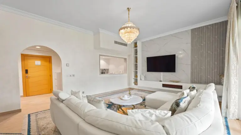 a living room with a white couch and a tv at 2BDR Luxury Apartment in Palm in Dubai