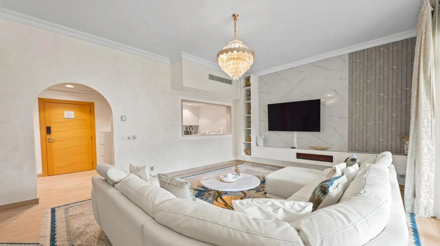 a living room with a white couch and a tv at 2BDR Luxury Apartment in Palm in Dubai