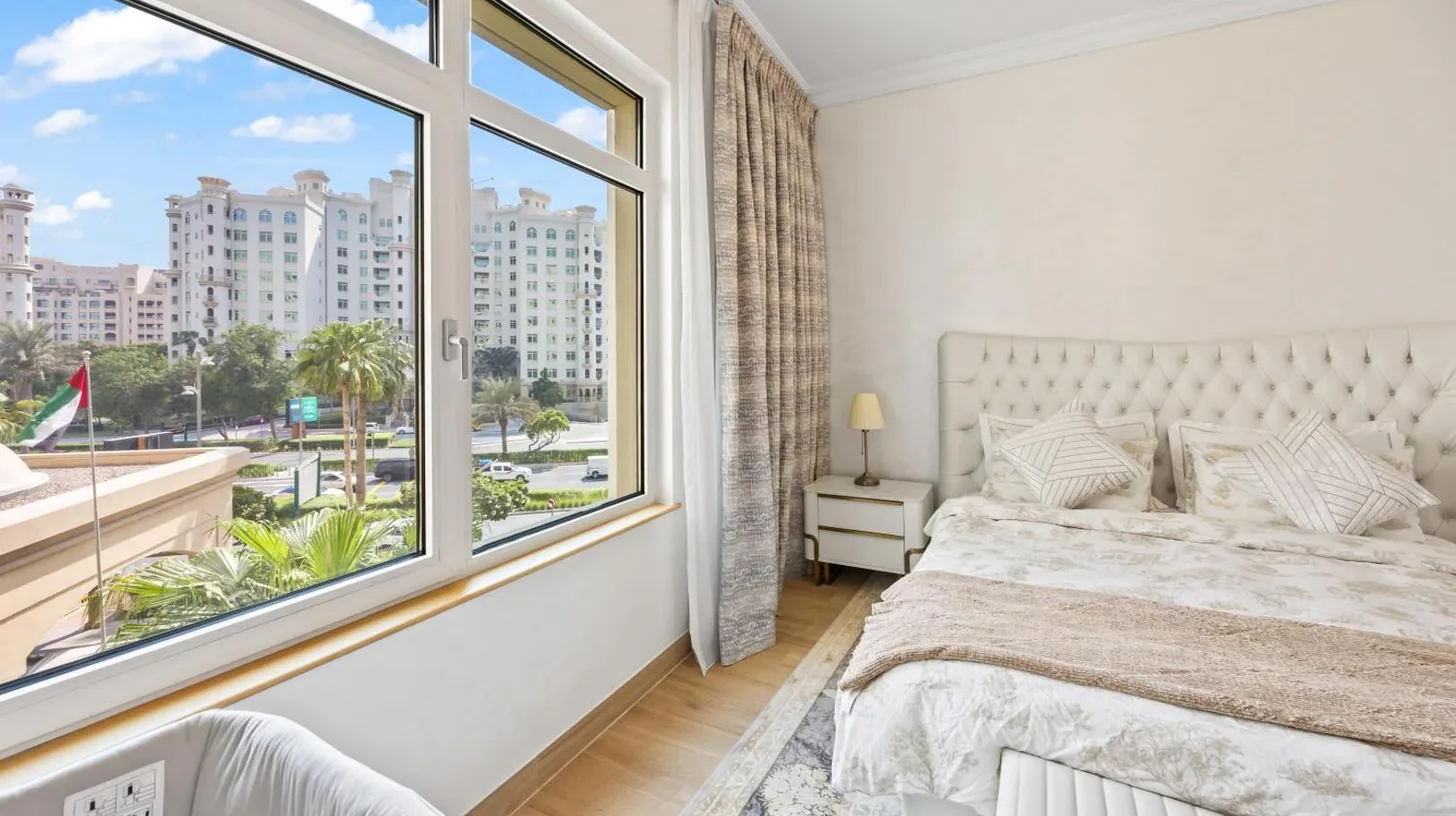 a bedroom with a bed and a large window at 2BDR Luxury Apartment in Palm in Dubai