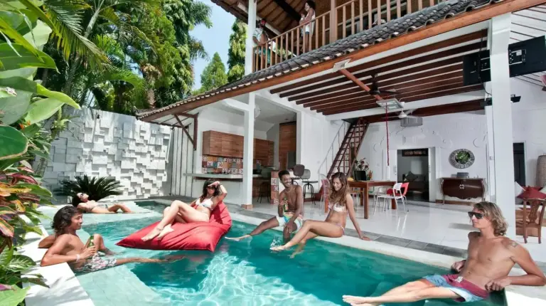 eine Gruppe von Personen, die im Schwimmbecken von 3BR Villa Hari - Special Stay Bonus - Minggu Villas Seminyak in Seminyak sitzt