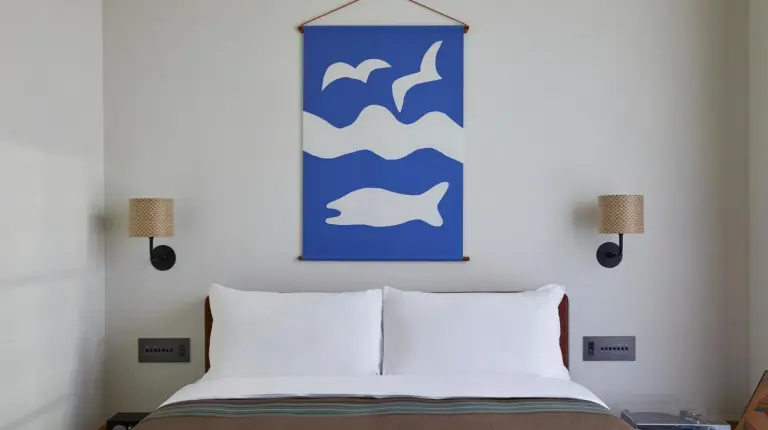 une chambre avec un lit et une peinture bleu et blanc à Ace Hotel Kyoto à Kyoto