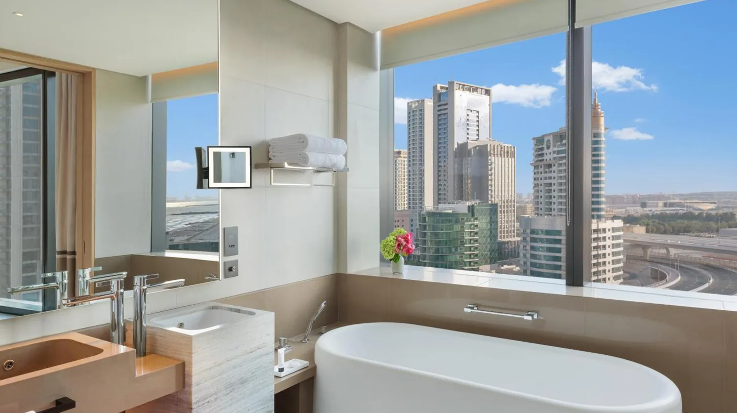 a bathroom with a large white tub and a large window at Address Beach Resort in Dubai