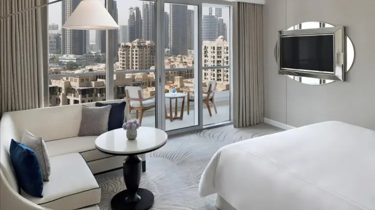 une chambre d'hôtel avec un lit, un canapé et une télévision à Address Downtown à Dubaï