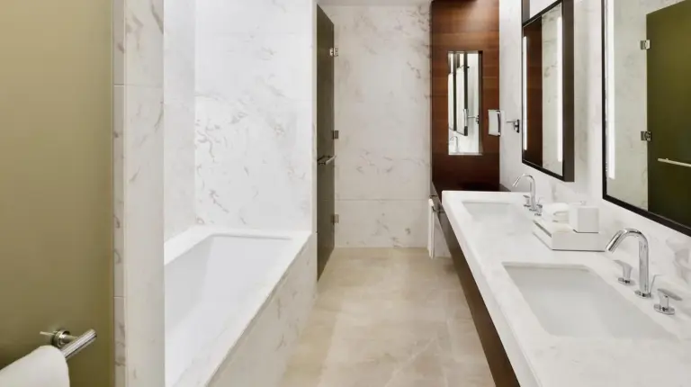 a bathroom with two sinks and a large window at Address Sky View