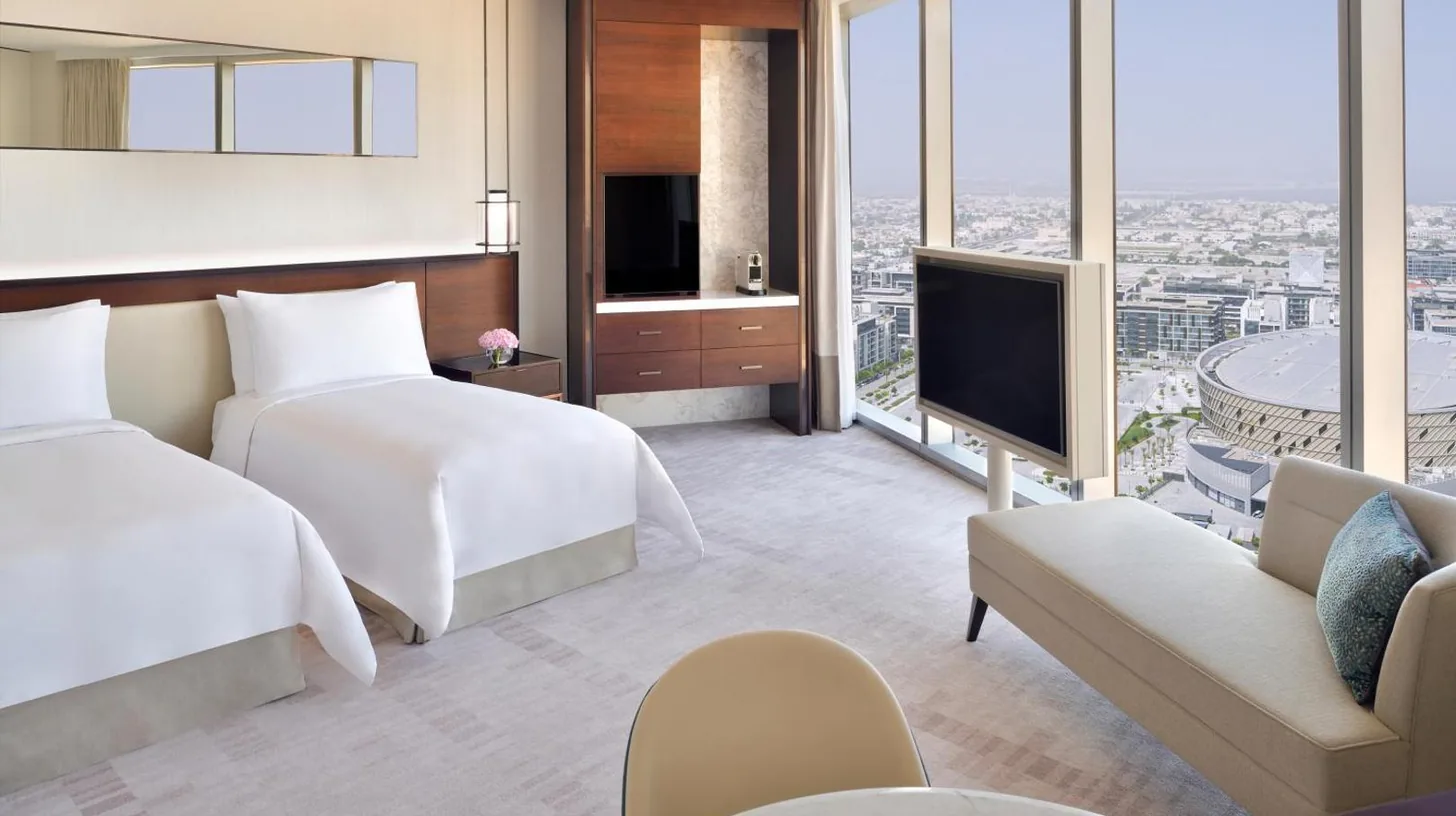 a table with a bowl of fruit and a vase of flowers at Address Sky View