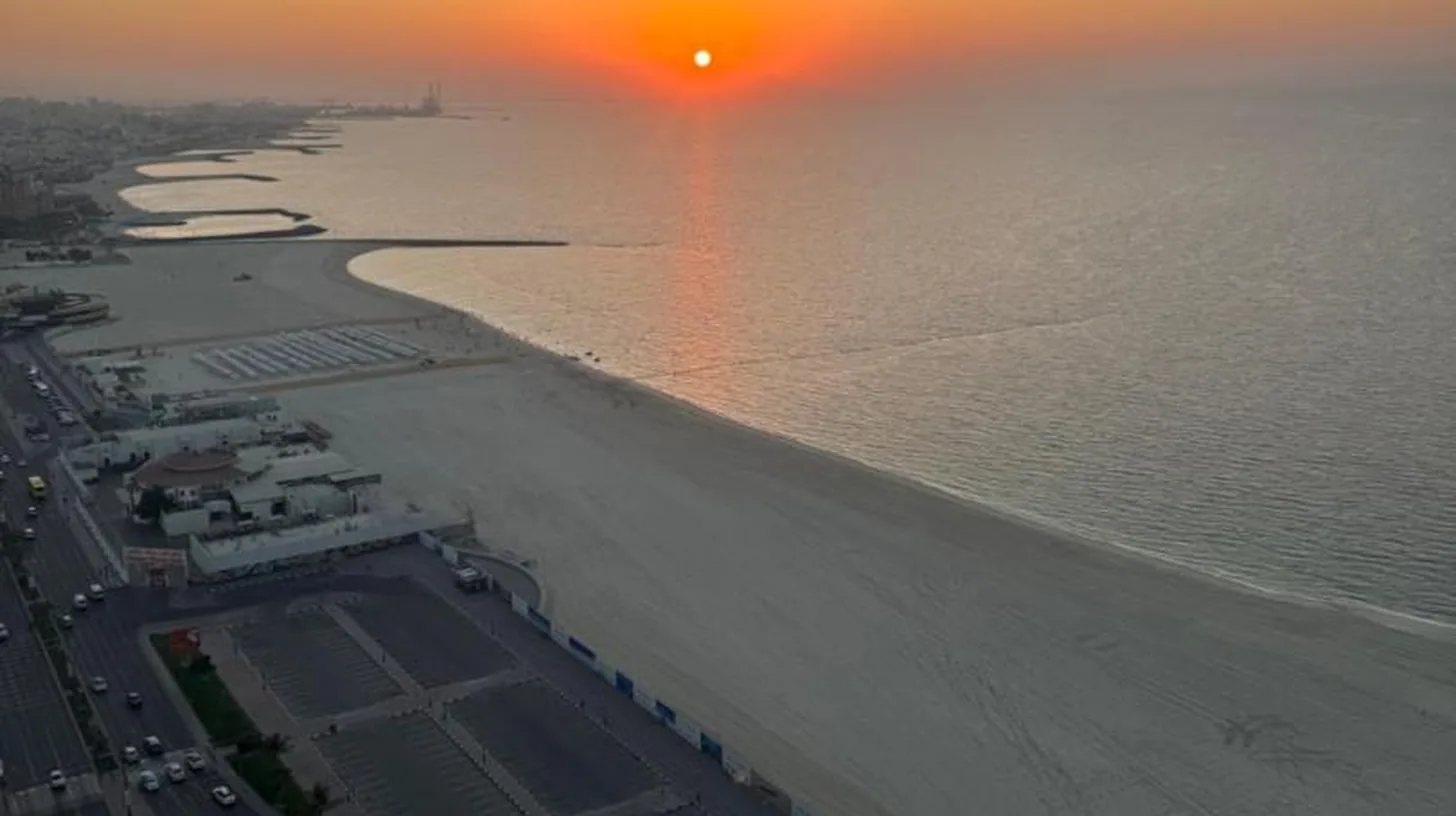 an aerial view of the beach at sunset at Ajman Luxurious Holiday Homes in Ajman
