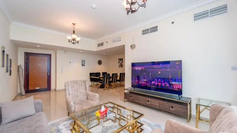 a living room with a flat screen tv and furniture at Ajman Luxurious Holiday Homes in Ajman