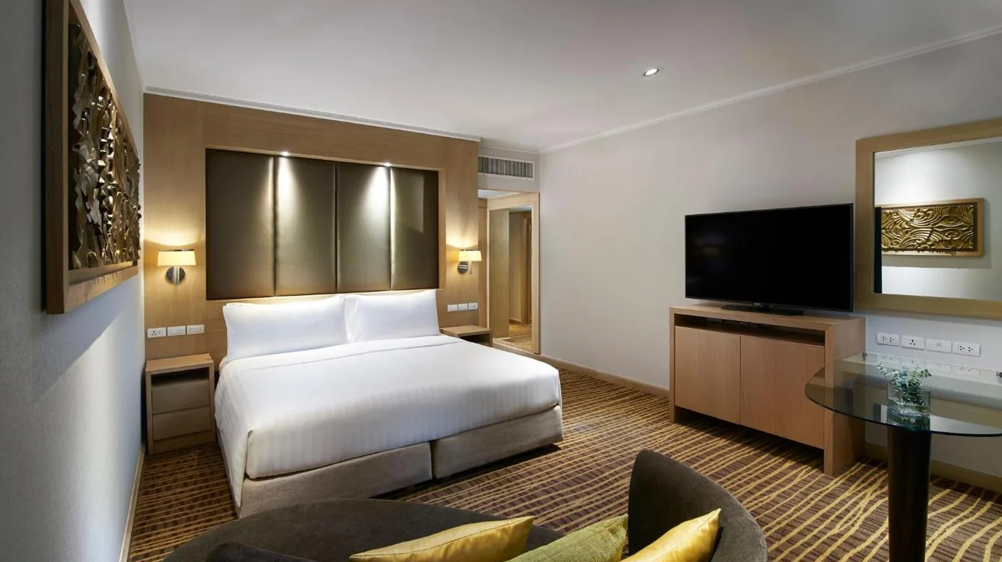 a hotel room with a bed and a tv at Amari Bangkok in Bangkok