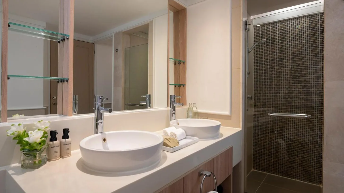 a bathroom with two sinks and a shower at Amari Bangkok in Bangkok