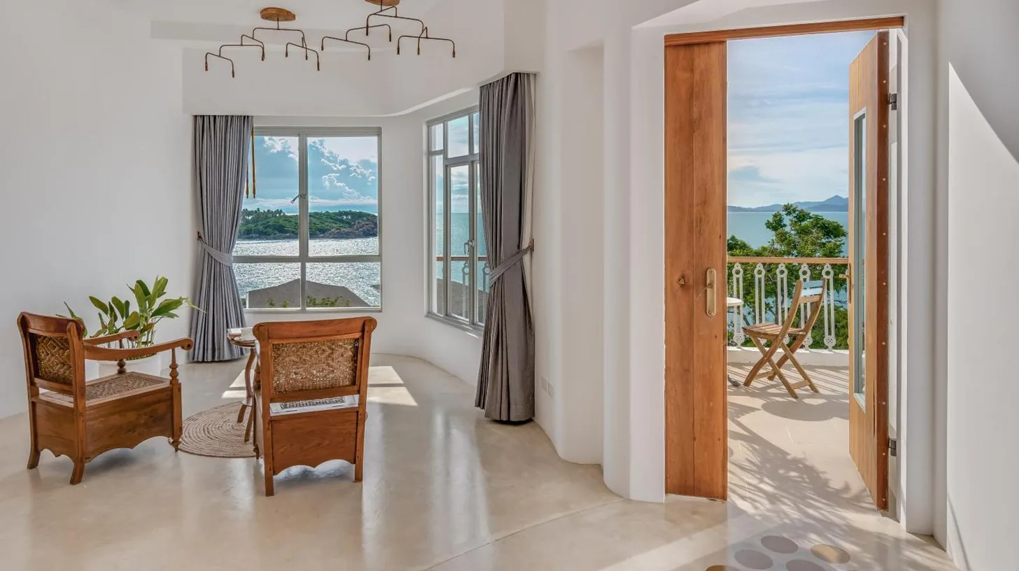 a living room with a view of the ocean at Ampersand Resort in Bophut