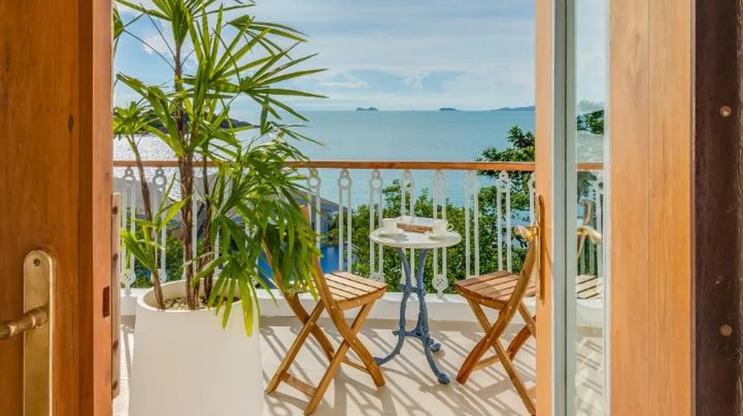 a balcony with a potted plant and a view of the ocean at Ampersand Resort in Bophut