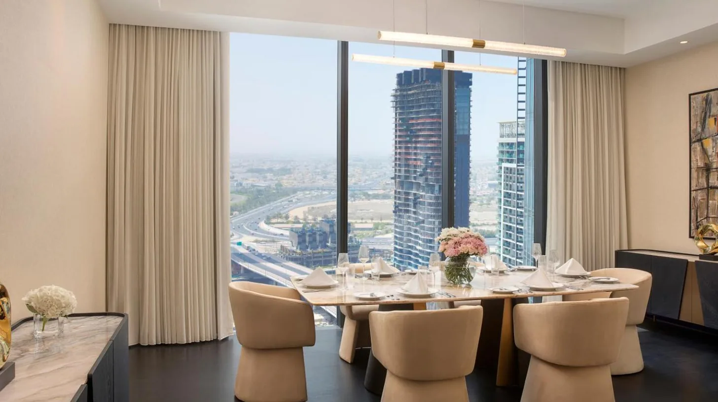 a dining room with a table and chairs and a large window at Anantara Downtown Dubai in Dubai