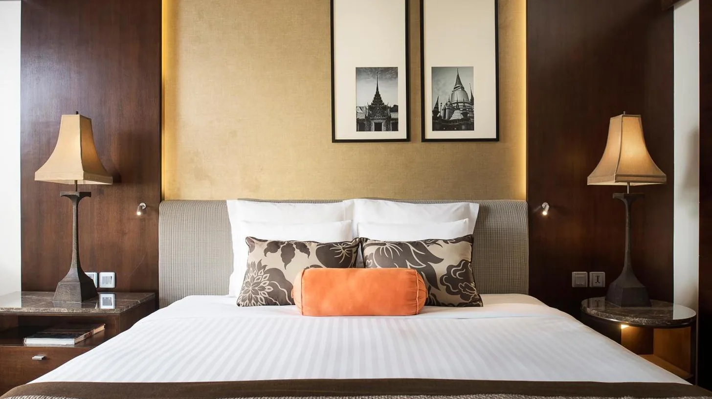 a bedroom with a large bed with two lamps at Anantara Riverside Bangkok Resort in Bangkok