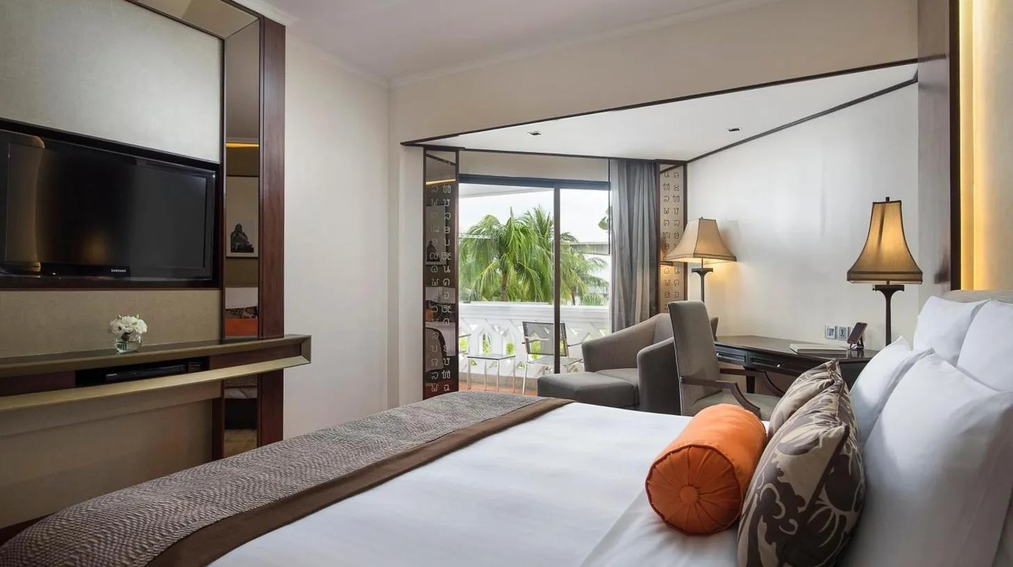 a hotel room with a bed with a flat screen tv at Anantara Riverside Bangkok Resort in Bangkok