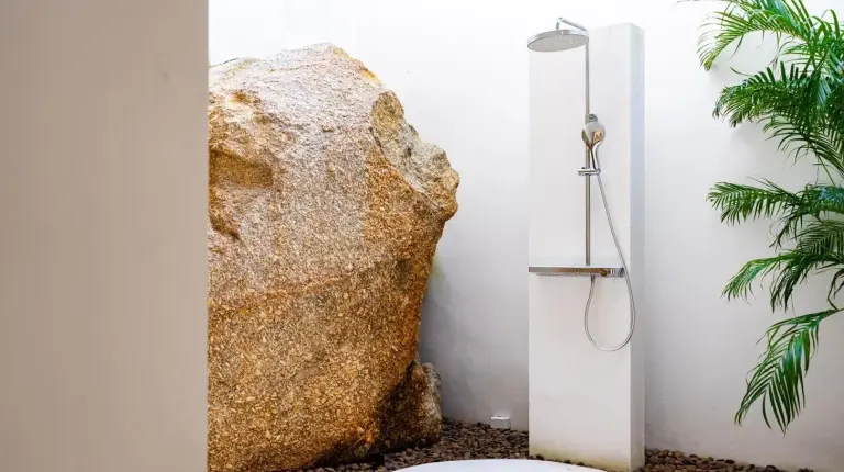 a bathroom with a shower next to a large rock at Anzhu Seamate Villa Samui in Lamai