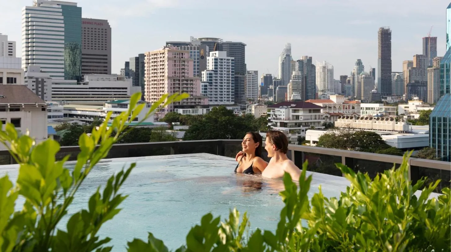 two women in a hot tub with a city skyline at Ascott Embassy Sathorn Bangkok in Bangkok