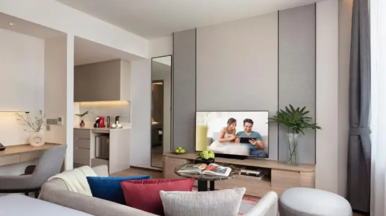 a living room with a couch and a tv at Ascott Embassy Sathorn Bangkok in Bangkok
