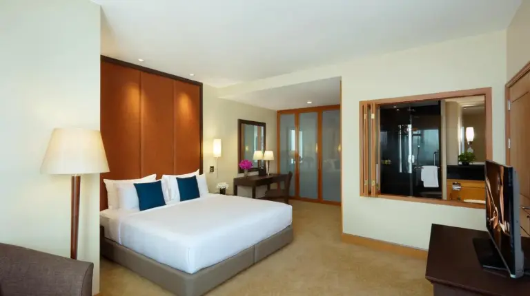 una habitación de hotel con una cama y un televisor en Ascott Sathorn Bangkok en Bangkok