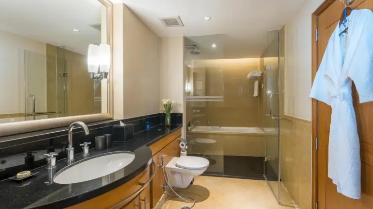 un baño con un lavabo, un inodoro y una ducha en Ascott Sathorn Bangkok en Bangkok