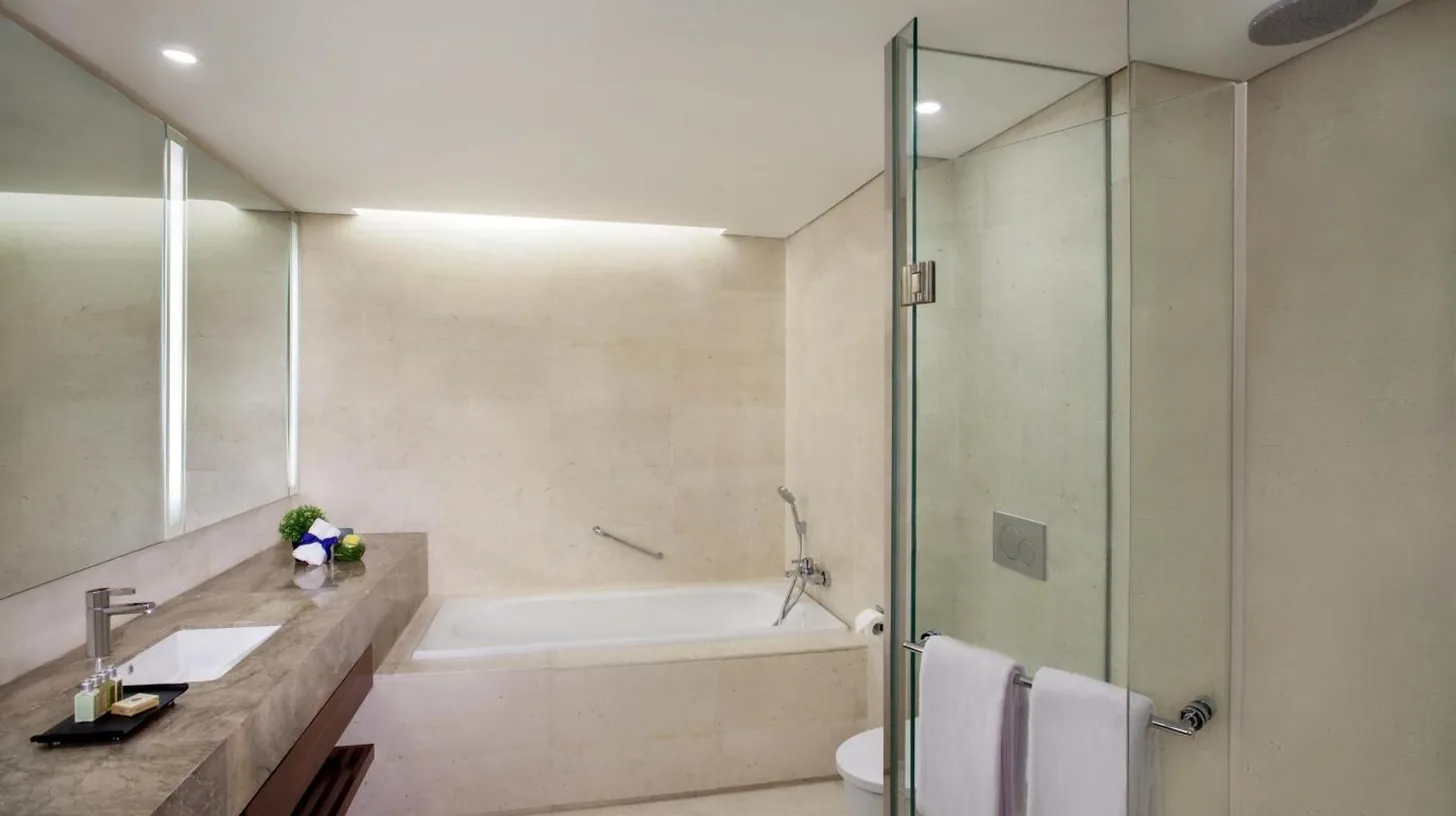 a bathroom with a tub and a sink and a shower at Ascott Sudirman Jakarta in Jakarta