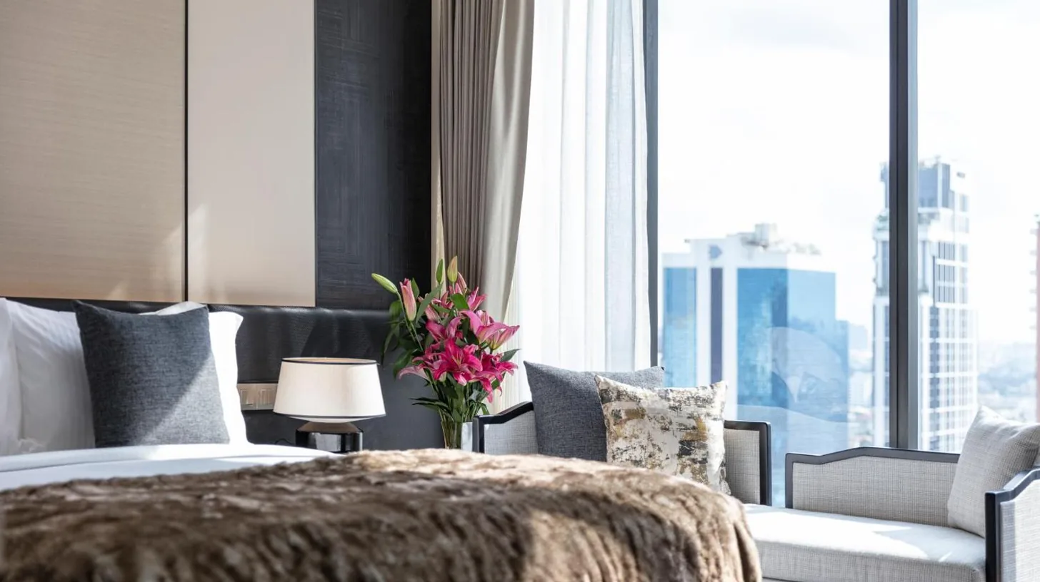 a bedroom with a bed and a large window at Ascott Thonglor Bangkok in Bangkok