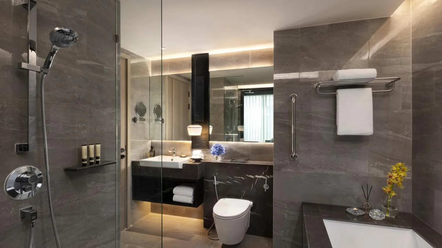 a bathroom with a shower and a toilet and a sink at Ascott Thonglor Bangkok in Bangkok