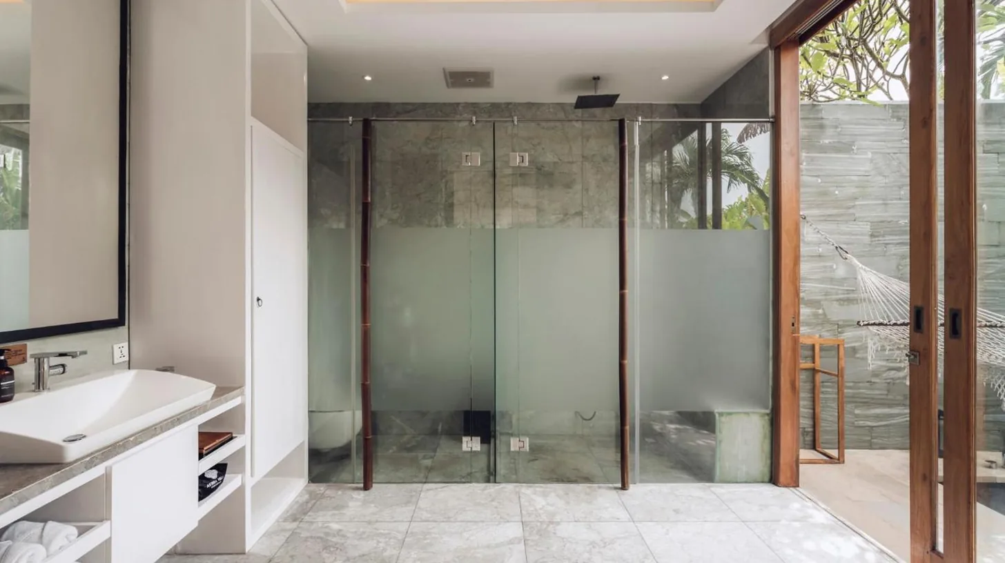 a bathroom with a glass shower and a sink at Astera Villa Seminyak by Ini Vie Hospitality in Seminyak