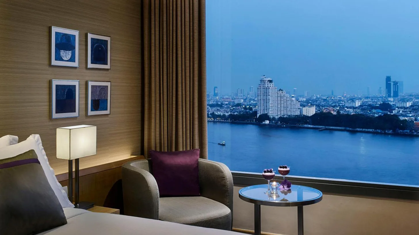 a room with a window with a view of the river at Avani Plus Riverside Bangkok Hotel in Bangkok