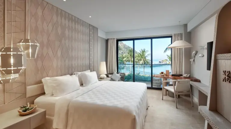 a hotel room with a large bed and a desk at AYANA Komodo Waecicu Beach in Labuan Bajo
