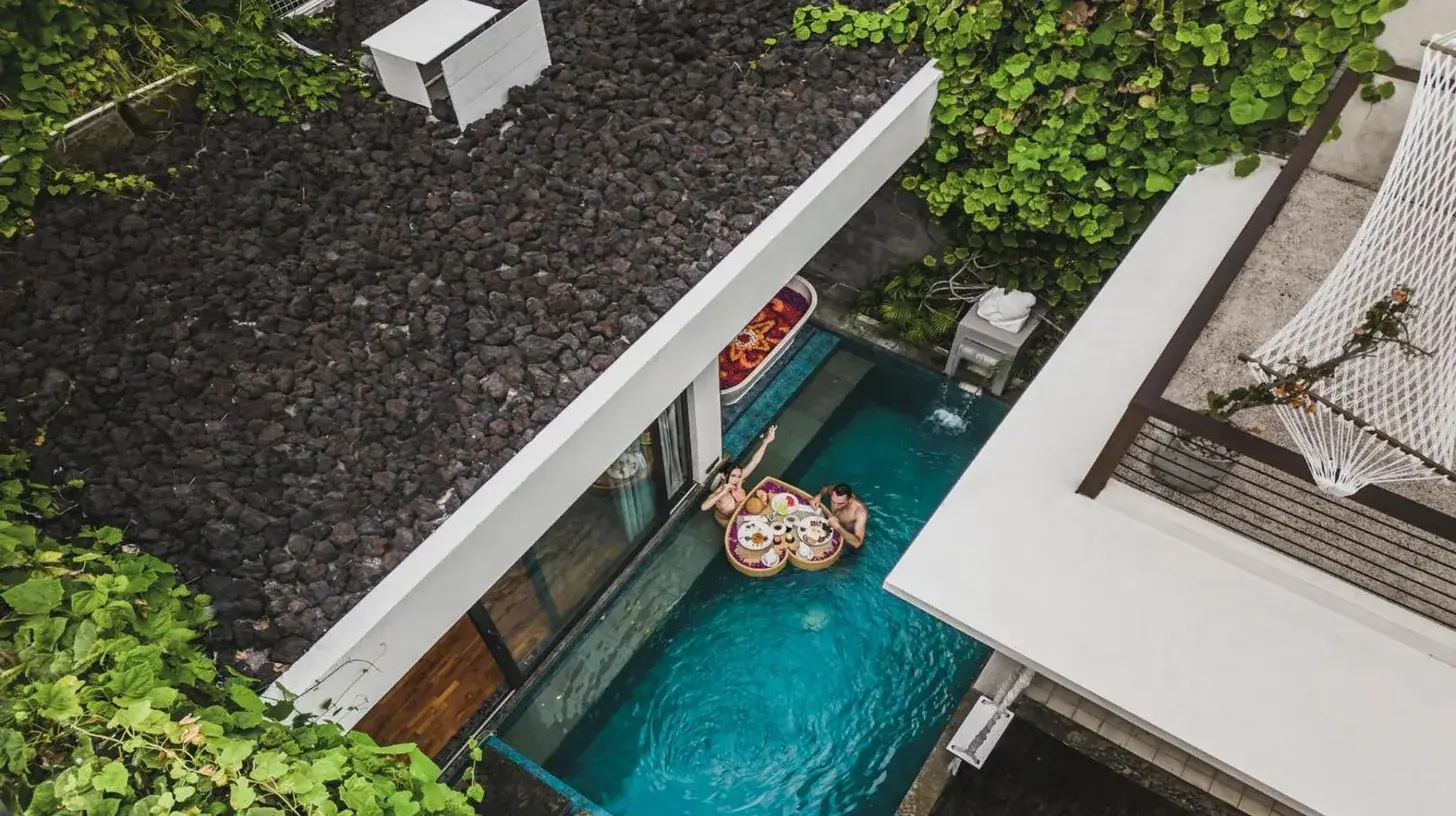 eine Luftaufnahme eines Swimmingpools mit einem Floß in einem Haus bei Ayona Villa Seminyak by Ini Vie Hospitality in Seminyak