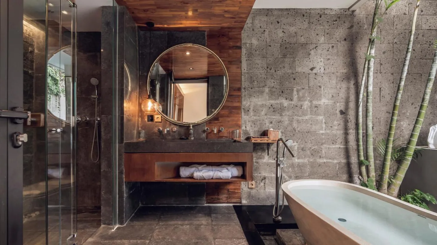 ein Mann und eine Frau liegen im Bett in einem Haus bei Ayona Villa Seminyak by Ini Vie Hospitality in Seminyak