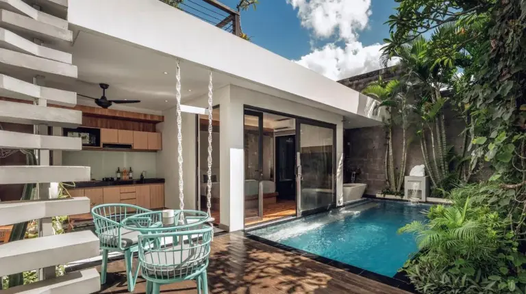 ein Mann und eine Frau sitzen an einem Tisch vor einem Herz bei Ayona Villa Seminyak by Ini Vie Hospitality in Seminyak