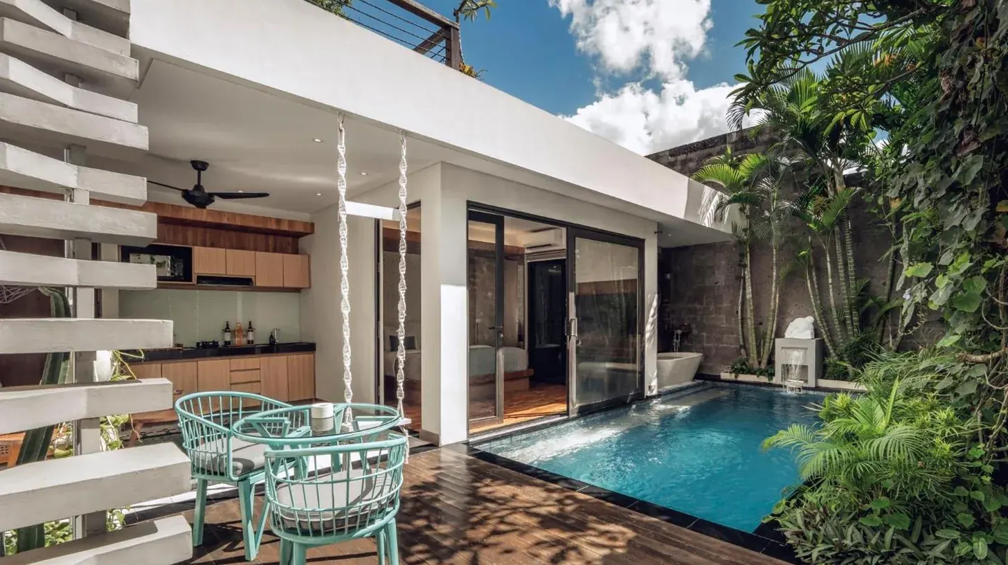ein Mann und eine Frau sitzen an einem Tisch vor einem Herz bei Ayona Villa Seminyak by Ini Vie Hospitality in Seminyak