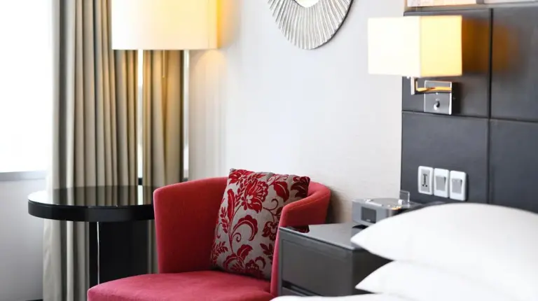 a red chair sitting next to a table in a hotel room at Bangkok Marriott Hotel Sukhumvit in Bangkok