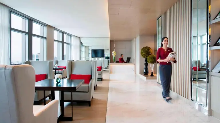a woman walking down a hallway in a building at Bangkok Marriott Hotel Sukhumvit in Bangkok
