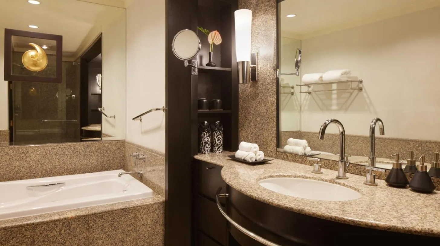 un baño con un lavabo y un gran espejo en Banyan Tree Bangkok en Bangkok