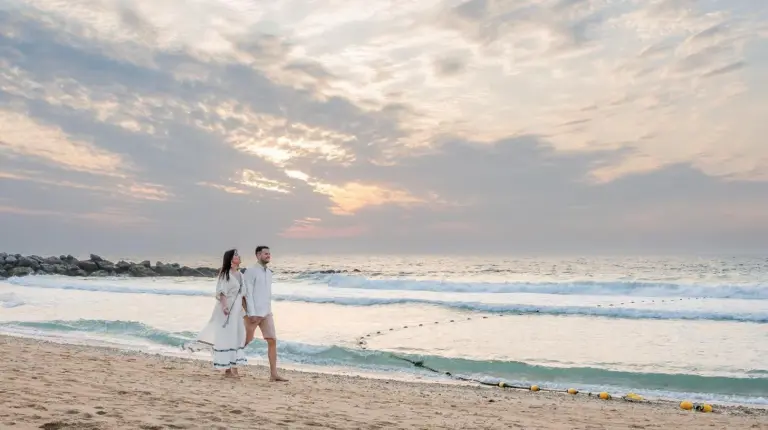 un homme et une femme marchant sur la plage à Banyan Tree Dubai at Bluewaters à Dubaï