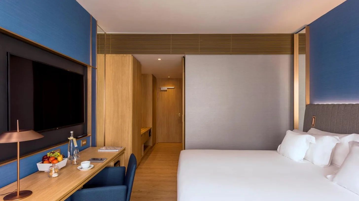 une chambre d’hôtel avec un lit, un bureau et une télévision à Barceló Tanger à Tanger