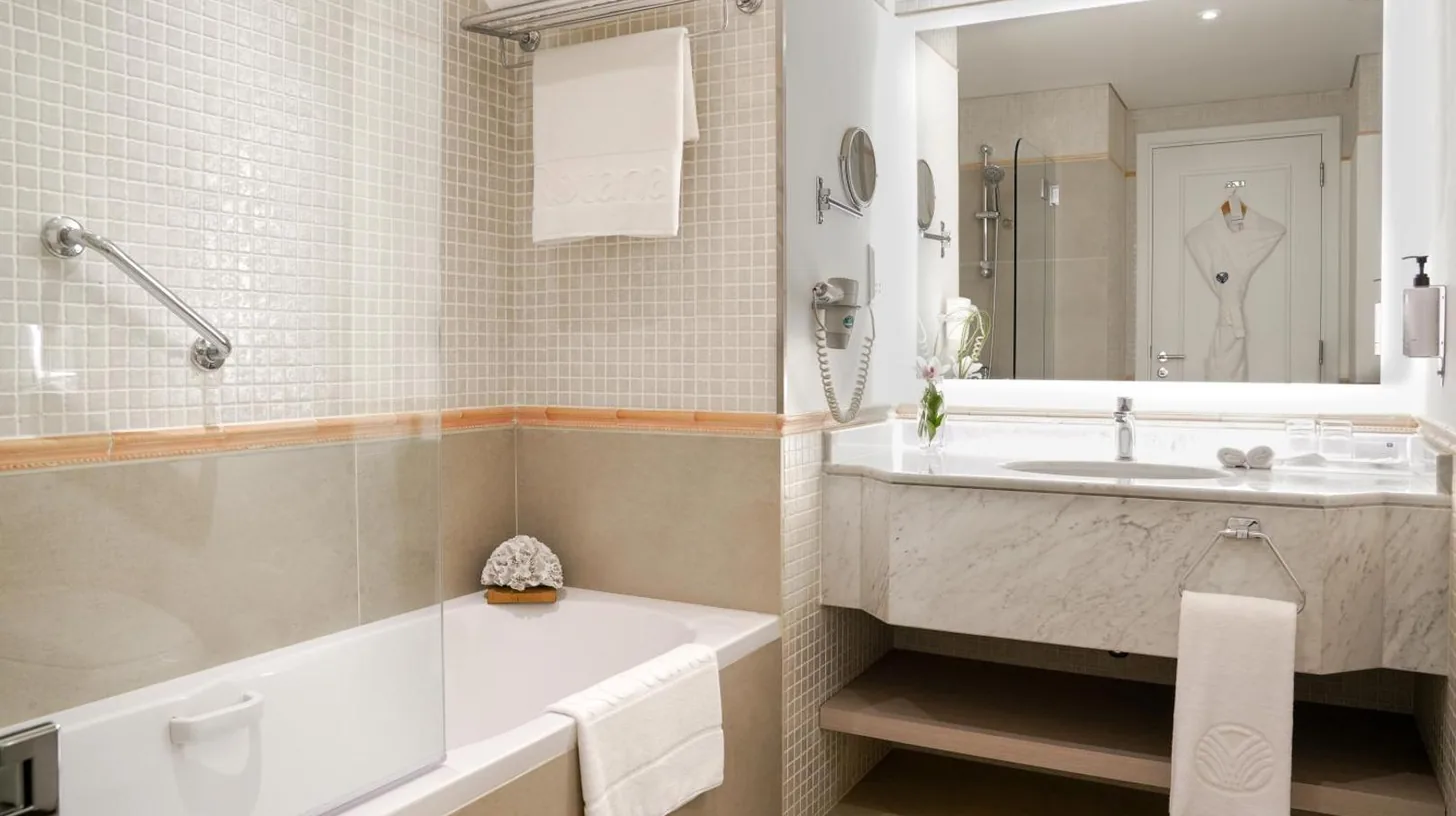 a bathroom with a tub and a sink at Beach Rotana – All Suites in Abu Dhabi