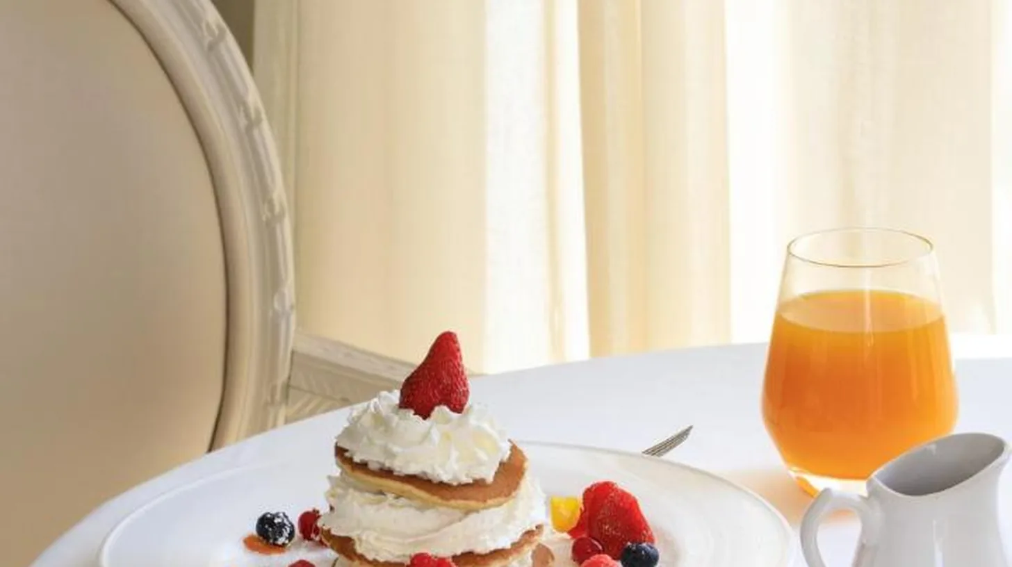 a plate with a cake and berries on a table at Boscolo Nice Hotel & Spa in Nice