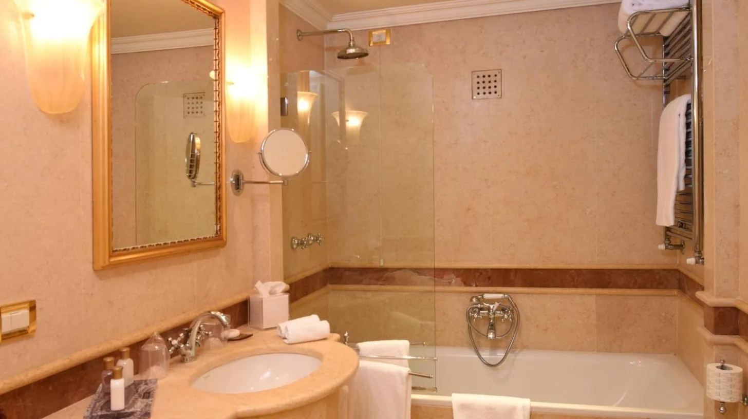 a bathroom with a sink and a tub and a mirror at Ca' Sagredo Hotel in Venice