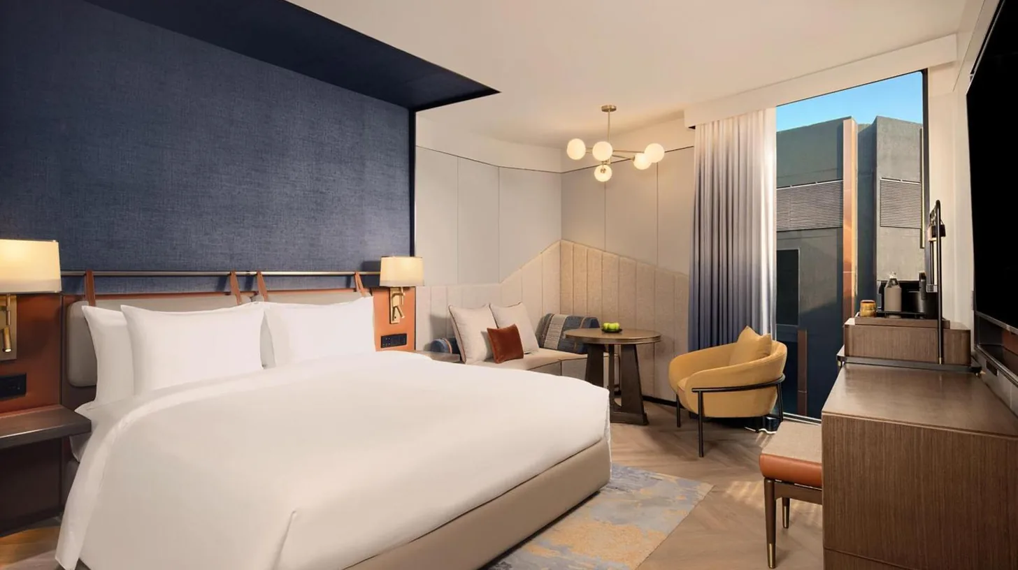 a bedroom with a large white bed and a desk at Canopy By Hilton Bangkok Sukhumvit in Bangkok